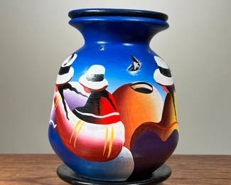 PAINTED CANDLE VASE | Hand-painted Mexican or South American candle vase with star and moon cutouts and removable base to place tea candle inside. Decorated in vibrant colors, the vase depicts female figures with white hats against a bright blue background. - h. 6 x dia. 4.5 in