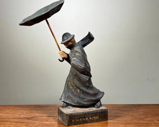 CHOVENDO WOOD SCULPTURE | Shows man in heavy rainstorm with umbrella blown out. Signed “Chovendo” on bottom. -  l. 6 x w. 3.5 x h. 9.5 in
