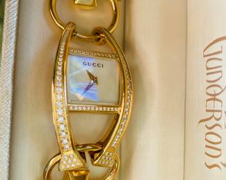 LADIES 18K GOLD GUCCI WATCH
One lady's 18K yellow gold, diamond GUCCI Swiss made wristwatch. Stamped *18K*. The face of the watch features a mother of pearl dial with gold hour and minutes hands. In very good condition.