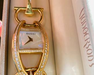 LADIES 18K GOLD GUCCI WATCH
One lady's 18K yellow gold, diamond GUCCI Swiss made wristwatch. Stamped *18K*. The face of the watch features a mother of pearl dial with gold hour and minutes hands. In very good condition.