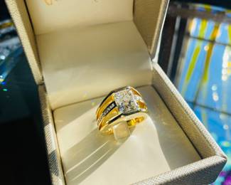 DIAMOND RING:
One 18K yellow gold diamond ring featuring one cut-cornered rectangular modified brilliant "radiant cut diamond of 4.02ct, thirty (30) round full cut diamonds and two (2) princess cut diamonds aii totaling 0.80ct. The radiant cut diamond is center bar set with diamonds channel set down the center of each open shoulder and one princess flush set on each profile. The 11.8mm high polish Euro shank tapers to 5.4mm at the back and features inside soldered sizing bars.