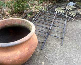 Huge terra cotta pot, metal railing pieces, metal/iron wheel.