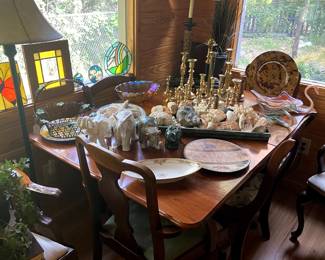 Drop leaf antique table, with mis-matched chairs, collection of brass candlesticks, elephant figurines, decorative shells displayed on copper tray.