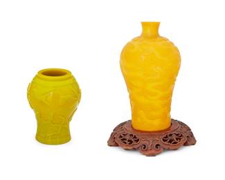 1050
20th century
Two Chinese Peking Glass Vases
Each appears unmarked
Comprising one goldenrod-colored glass baluster-form vase incised with dragon and cloud motifs and one yellow glass vase with molded lotus flower and avian motifs, along with a carved wood stand, 3 pieces
Larger: 9.5" H x 5.5" Dia.
Estimate: $100 - $150