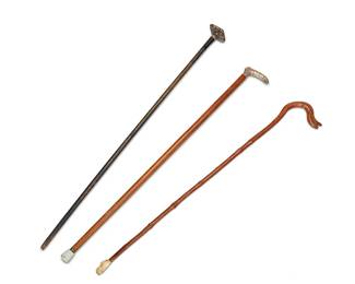 1057
Early/mid-20th century
A Group Of Antique Carved Wood Walking Canes
Each appears unmarked
Comprising one carved wood cane with a lizard handle, one ebonized wood cane with a silver metal overlay handle, and one wood cane with a silver metal handle embossed with floral and scroll motifs, 3 pieces
Largest: 33.5" H x 2.25" W; smallest: 32" H x 5" W
Estimate: $200 - $400