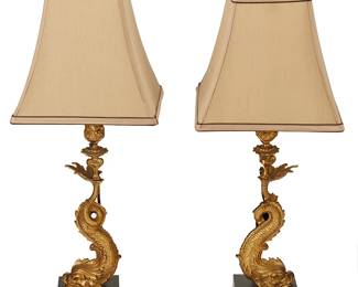 1149
Early/mid-20th century
A Pair Of Neoclassical-Style Gilt-Bronze Table Lamps
Likely a pair of gilt bronze candlesticks retrofitted as lamps, each with a Florentine dolphin beneath a foliate bobeche and a squared silk shade, set upon a black enameled metal base, electrified, 2 pieces
Each: 24" H x 10" Dia.
Estimate: $300 - $500