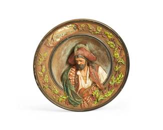 1151
Late 19th century
Two Continental Wall Hanging Plates
Each stamped to verso: Musterschutz / JM; one stamped: 5753; one stamped: 5746
The molded and polychrome ceramic plates in high relief, one depicting a man on horseback hoisting a white flag, the other depicting a musician with a violin centering holly leaves and berries around the border, 2 pieces
Larger: 2.25" H x 15.325" Dia.; smaller: 2.5" H x 12.125" Dia.
Estimate: $500 - $700