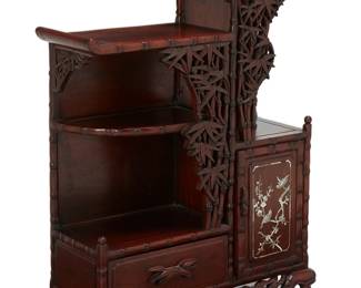 1189
Early/mid-20th century
An East Asian Carved Wood Display Cabinet
The small display cabinet with five shelf surfaces, one drawer, and a cabinet with mother of pearl inlay depicting birds on branches with cherry blossoms, also featuring carved and pierced wood bamboo motif accents throughout, raised on carved wood feet
29" H x 22.5" W x 8.75" D
Estimate: $500 - $700