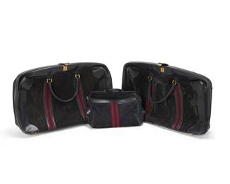 1259
Late 20th century
Three Vintage Gucci Leather Luggage Cases
Three works:

A pair of soft-sided single compartment black leather and suede suitcases
Each marked to lock strap verso: Made in Italy by Gucci / 20; hardware marked: Gucci
Each with red and blue woven strapping and rolled leather handles, with narrow internal center frame and blue twill lining
Each: 21" H x 28" W x 8" D
2 pieces

A "G" Monogram navy suede and leather carry-on travel bag
Marked to interior leather tab: Made in Italy by Gucci / 24; hardware and zippers marked: Gucci
With red and blue woven strapping, brass-toned hardware, blue twill lining, inner frame to top, and two exterior zip pockets, and with associated detachable shoulder strap
12" H x 15.5" W x 5" D

3 pieces total
Estimate: $400 - $600