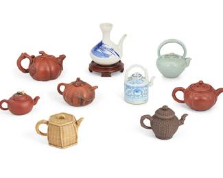 1342
20th century
A Group Of East Asian Ceramic Teapots
Three marked with kanji characters to underside
Comprising four Yixing zisha clay gourd-form pots, two basket-form pots, one blue and white pot on a wood stand, one blue and white pot with bridge handle, and one cerulean pot, 9 pieces
Largest: 7.125" H x 7.25" W x 6" D; smallest: 3.25" H x 6" W x 3.75" D
Estimate: $400 - $600