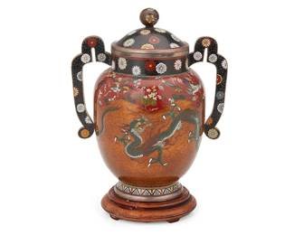 1348
20th century
An East Asian Cloisonné Vessel
Appears unmarked
The polychrome enamel and white metal alloy lidded vase with two opposed handles featuring dragons on an orange micaceous ground and phoenixes and floral motifs on a red ground, set on a wood base
With base: 8" H x 7" W x 4.75" D
Estimate: $600 - $900