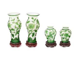 1364
20th century
A Group Of Chinese Peking Glass Vases
Two with paper label to the underside of wood stand: Made in the Peoples Republic of China
Four vases comprising one larger near pair and one smaller near pair, all conformingly designed in cameo-style with green foliate motifs atop a white ground; each with carved wood stands, 8 pieces
Largest with stand: 9.5" H x 3.75" Dia.; smallest with stand: 6" H x 3.25" Dia.
Estimate: $200 - $300