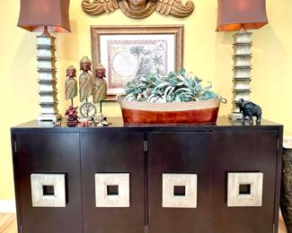 $150 each (2 available); 15 x 8 x 42; tall, modern table lamp with chocolate, silk shade and burnished, gold-like finish;                                                                                                                                                                                  $150; 40 x 7 x 16; "Protective Angel" wall hanging (small chip above right wing behind head);                                         $80; 35 x 29; Map of the Americas in suede-like frame;                      $42; 13 x 4 x 22; three person carved wood decor;                                                       $32; 30 x 12 x 8; long, metal bucket with rope handles, perfect for hosting parties;                                                                                                                                                        $28 each (2 available); faux eucalyptis and olive branch wreaths;                                                                                      