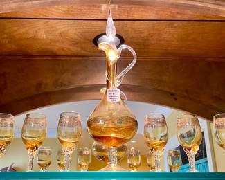 $160; 16.5”h (decanter); 4.5”h (glasses) amber-colored decanter with six cordial glasses