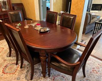 The matching oval table w/ 8 leather chairs