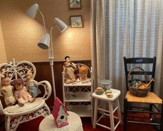white wicker furniture, black woven chair, antique dolls, vintage child's tea set, white multi-light floor lamp
