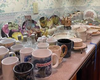 array of antique and vintage kitchenware, mugs, decorative plates, mixers, kettle, canisters