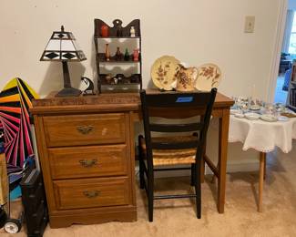 wood desk, vintage woven chair, tiffany-style table lamp, vintage dishes, antique curio shelf
