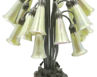 Early 20th century, maker's stamp to underside ''Buffalo / Metal Works / Pasadena". The patinated bronze foliate cluster base issuing 18 stems terminating in iridescent gold lily form shades. Works well. With dimmer. Measures 16"x16"x21". Weight 20 pds.