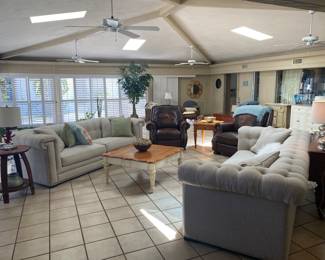 Cream colored square Surray Sofa's 8.5', Ethan Allen Coastal Square Coffee Table and side table. Anden Barrell side table. Overstuffed leather recliners. Vinyl Plantation shutters, dropped ceiling fans. 