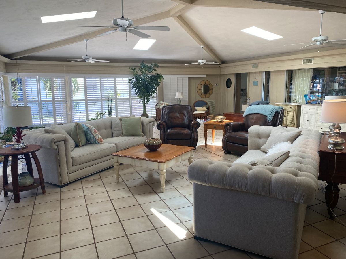Cream colored square Surray Sofa's 8.5', Ethan Allen Coastal Square Coffee Table and side table. Anden Barrell side table. Overstuffed leather recliners. Vinyl Plantation shutters, dropped ceiling fans. 
