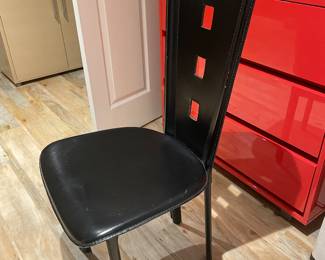Black leather covers entire chair, including legs, with black stitching.