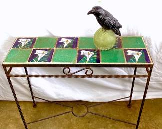 JIFI901 Vintage Wrought Iron Table Decorative Raven Floral tile table top sits atop wrought iron base measures approximately 25.5' wide x 22' high x 9' deep. Raven perched upon green sphere measures approximately 5.5' wide x 8.5' tall.