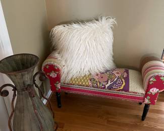 Settee with pillow and metal vase with stand
