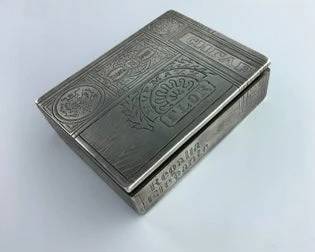 About
Specialists
Depart
Russian .875 Silver Trompe l'Oeil Cigar Box, Moscow, c. 1871, Khlebnikov, maker, assayer mark "AK," gilt interior, with simulated wood grain panels and trade labels to all four sides, cover inscribed "H. UPMANN/FLOR," 
. 26.9 troy oz.
Good overall condition with only minor marks