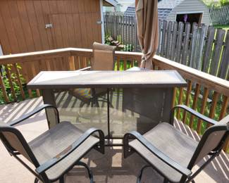 outdoor bar with three raised chairs