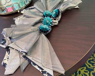 Set of 4 multi-layer napkins in blue and silver gathered in blue floral napkin rings