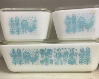 A great vintage Pyrex refrigerator set in Amish Butterprint pattern. Set includes approximately 7-by-9-inch pan on bottom, loaf size on right and two small “fridgies” on left. Each piece has a clear glass lid. 