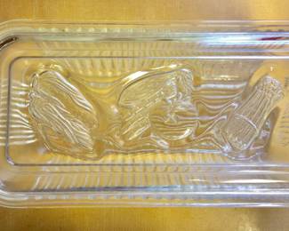 A clear, ribbed refrigerator dish and lid embossed with veggies, likely by GlasBake. 