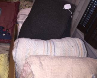 A wood blanket sandwiched between two cotton blankets with a chenille bedspread. 