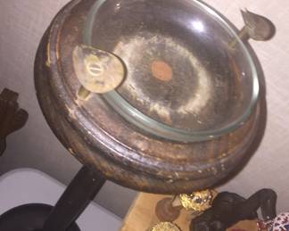 A standing ash tray with match holder and a few pieces from far-away travels. 