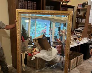 This is a rather large framed mirror.  The person holding the mirror is of average height, about 5 ft 9 in tall.