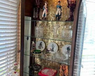 This shows the contents of one of the matching display or curio cabinets.  I see candlestick holders, decorative plates, and figurines.