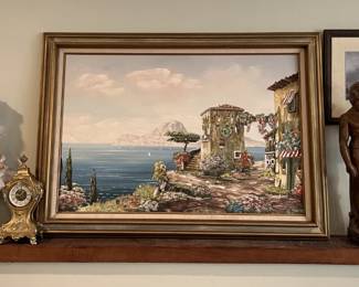 In the living room, above the mantelpiece there is a framed art, a small statue of David, a doll, a small clock, and another framed art piece on the wall.