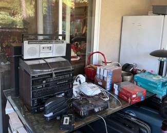 A compact stereo, a clock radio, and other electronic pieces here.