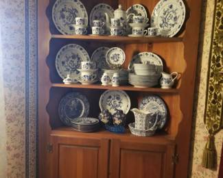 Pine corner cabinet filled with reproduction blue onion china.