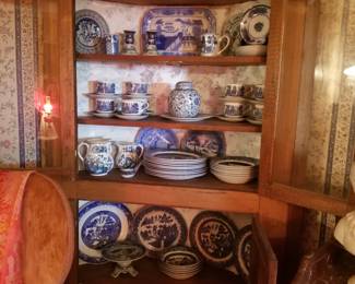 Handsome tall corner cabinet filled with blue willow china.