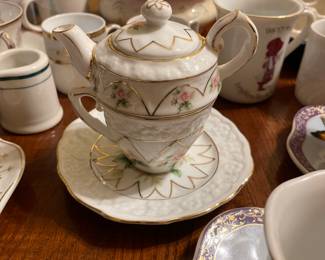 Tiny tea pot with cup and saucer