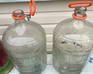 Five-gallon glass carboy bottles for beer brewing.