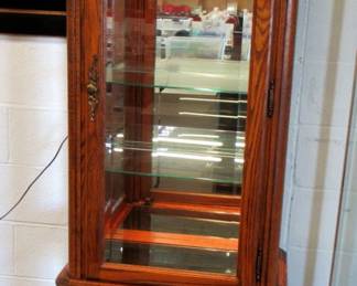 Beautiful Oak Curio Cabinet, lights up. In excellent condition. Cabinet has glass shelves and mirror back.