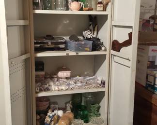 another metal cabinet full of vintage kitchen items. metal bread box on bottom shelf.