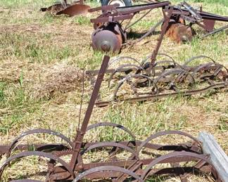 Vintage farm equipment located between the barn and house