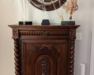 Antique English chest, with barley twist columns and carved fruit door, Original oil on canvas "Duke on Point" large Calla Lily custom boron glass sculpture, by Hans Godo Frabel, "Excalibur" by Hans Godo Frabel and an amazing lionfish glass sculpture on stand. 