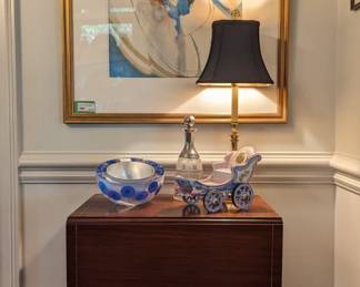 Vintage drop-leaf mahogany Pembroke table, signed art glass bowl, Baldwin brass Candlestick table lamp, cut glass/silver plated decanter, antique porcelain carriage and nicely framed, artist-signed contemporary artwork, by Susan Hollensbe, AK. 