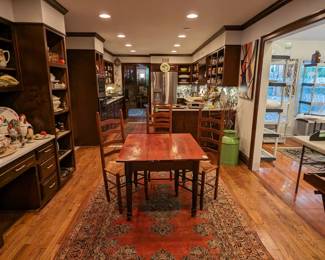 Wonderful antique heart pine farm table, with turned legs on casters, four matching American pine ladder-back chairs atop a vintage hand-woven Persian Sarouk rug.