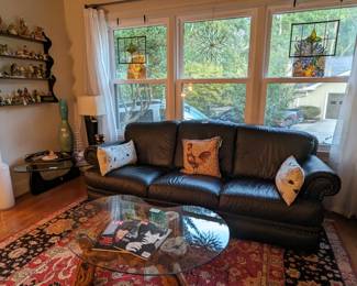 Black leather Natuzzi couch (Italy),  burlwood coffee table, w/kidney shaped glass top, mahogany wall shelf w/collection of vintage porcelain bird figurines, Noguchi-style wood/glass coffee table, pair of small stained glass windows and starburst leaded glass window - you have to squint to see it in this pic, but it's in the middle window. 